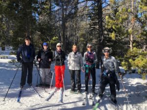 SVRG standing with skis and snowshoes in the forest.